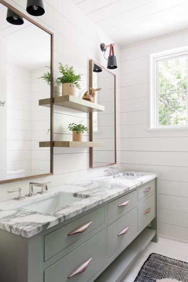 floating bathroom shelving with shiplap walls and marble countertop