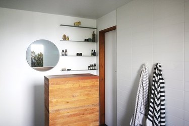 wooden cabinet, mirror, and minimalist floating bathroom shelving