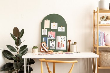 DIY Arched Mood Board sitting on white desk next to plant and bookshelf