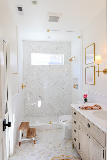 Marble tile in a shower with herringbone shower wall and window