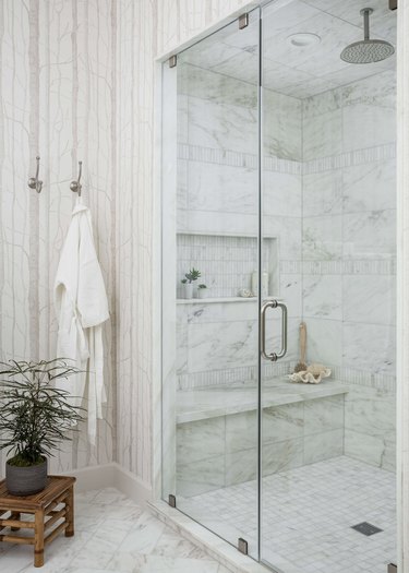 Marble tile in a shower with bench and storage in modern bathroom