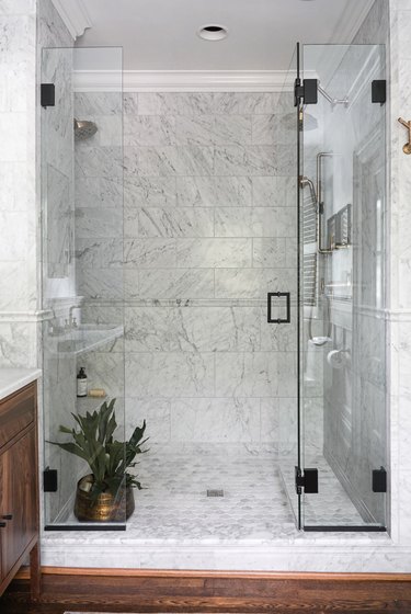 Marble tile in a shower with veining and glass doors
