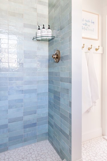 Blue shower tile in varying shades of subway tile in coastal bathroom