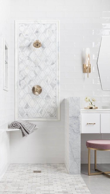 Marble tile in a shower with geometric tiles in white bathroom