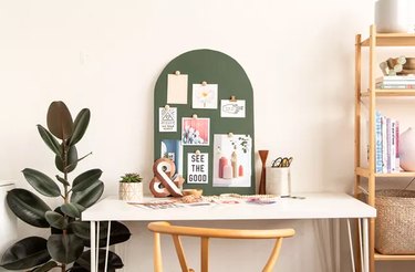 Green arched wood mood board on a desk