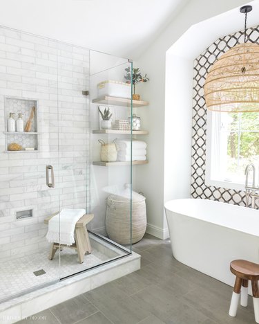 Marble tile in a shower with subway tile and hexagon floor tiles