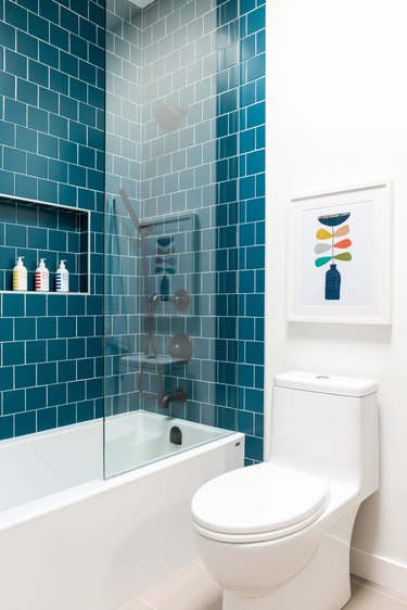 white bathroom with teal shower tile wall