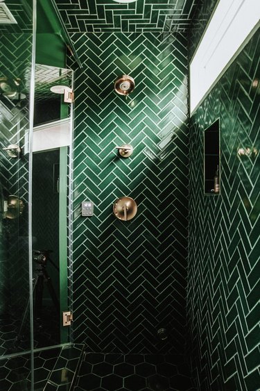 Green tile shower from floor to ceiling in herringbone pattern