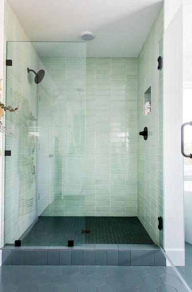 Green tile shower in light green with black and dark green accents