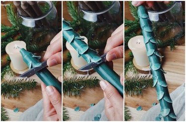 dark green taper candle being carved to look like a tree