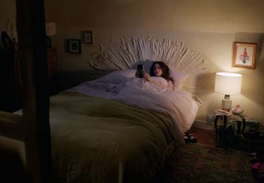 woman in darkly lit bedroom