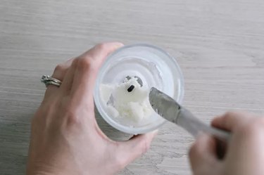 wax being scraped out of candle jar using butter knife