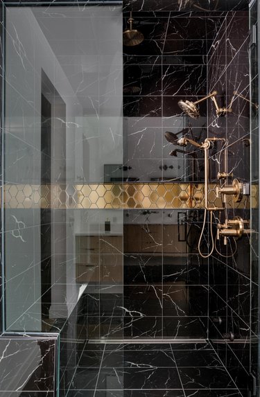 elegant black tile shower with marble surround and gold finished fixtures