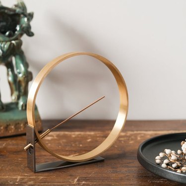 gold circular incense holder on wood table