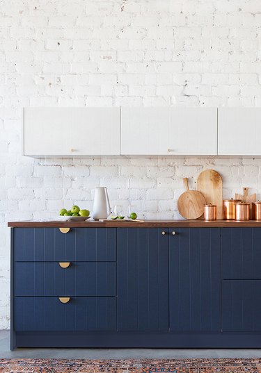 two tone kitchen with white upper cabinetry and navy blue beadboard cabinets