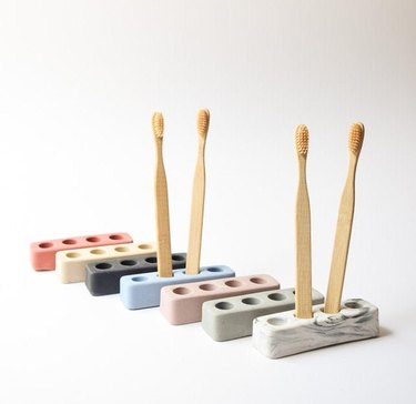 Toothbrush holders in a variety of colors with wood toothbrushes