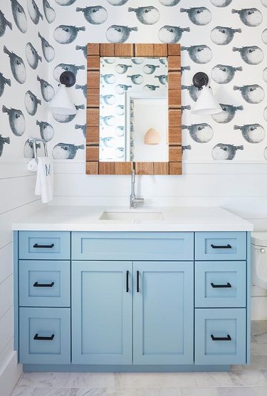 small bathroom wallpaper with blow fish print and blue vanity cabinet