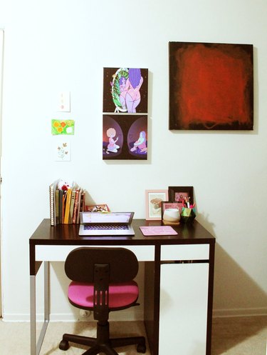 desk with pink chair and art on the wall