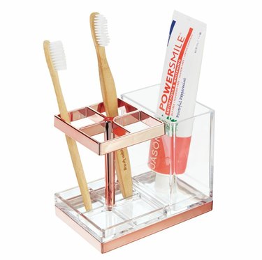 Rose gold and clear toothbrush holder with two toothbrushes and toothpaste