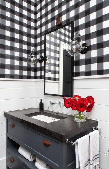 Black and white bathroom with large mirror, gray vanity and red flowers in vase and Wall-Mounted Bathroom Faucet
