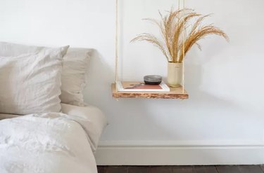 hanging wood nightstand next to bed