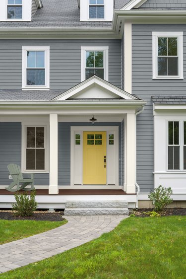 gray house exterior with yellow door