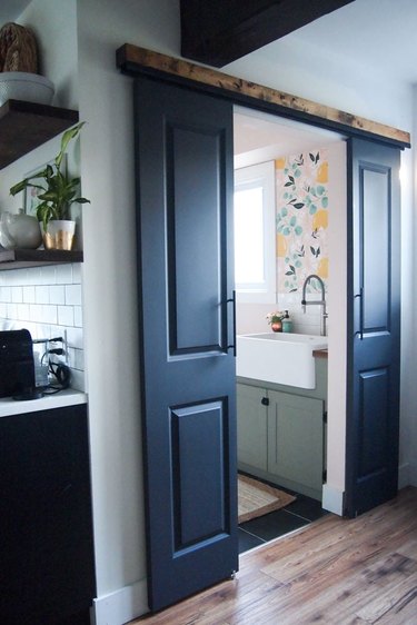 Small blue bathroom doors with green cabinets in bathroom