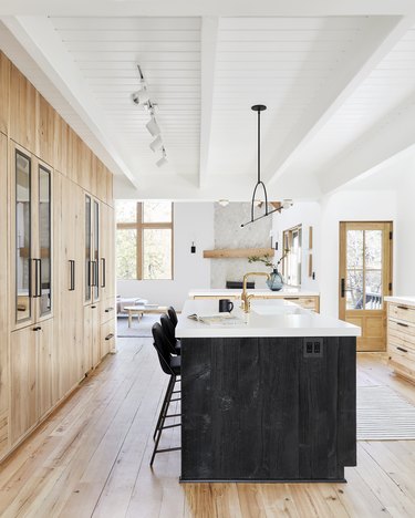 Rustic modern kitchen with black island and modern light fixture