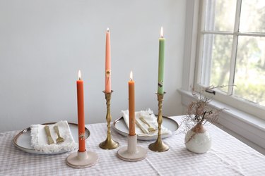 Four colorful pressed flower taper candles grouped together in table centerpiece