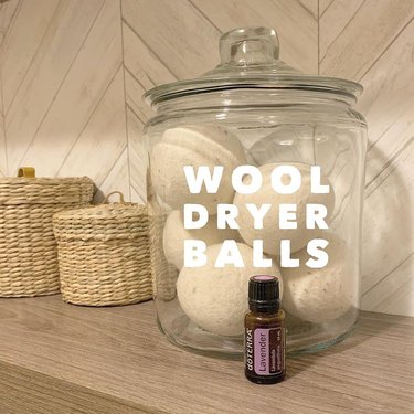 white wool dryer balls in glass jar with essential oil bottle