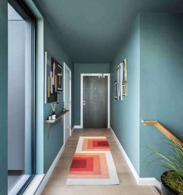 Teal Modern Hallway with orange geometric runner.