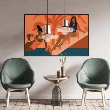 sitting area with painting of two women on orange stairwell and light green armchairs