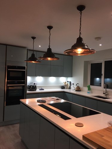black and copper pendant lights above island in dimly lit kitchen