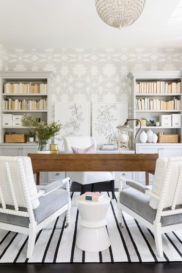 gray home office with gray and white floral wallpaper and wood desk