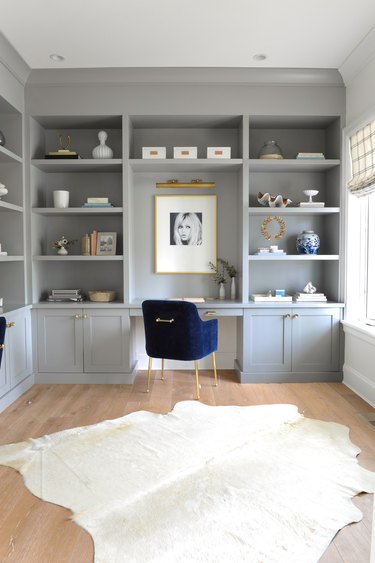 gray home office with built-ins and blue velvet desk chair