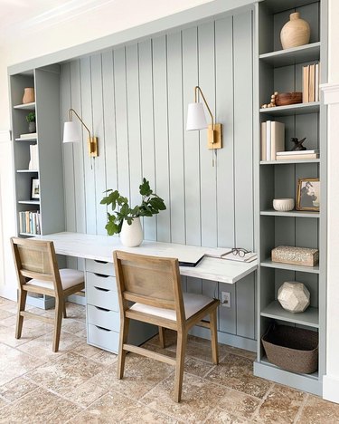 gray workspace with built-ins and brass wall sconces