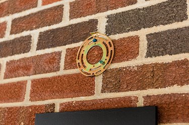 Install the hardware for the outdoor sconce on your porch wall.