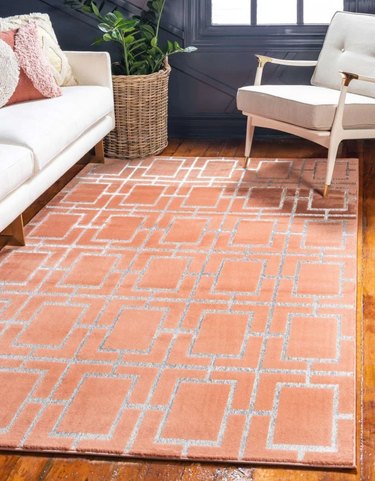 silver and orange geometric area rug in midcentury living space