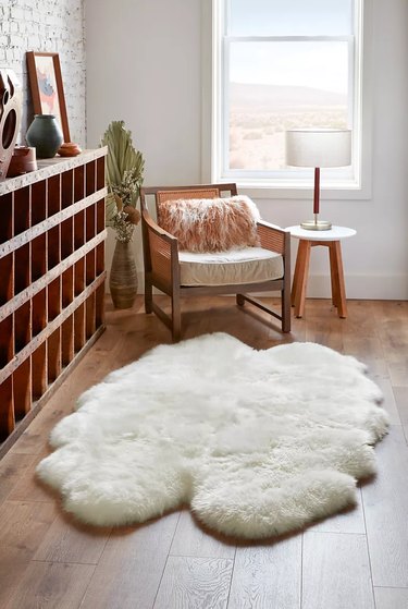 white plush sheepskin rug next to wooden shelf
