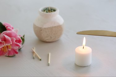 Holding butter knife over flame of tea candle