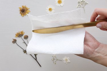 Wiping butter knife clean with a paper towel