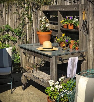 rustic potting table on casters with countertop and shelving