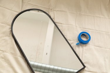 arched mirror and blue painter's tape