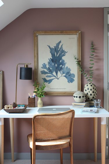 dark pink and purple walls in a home office with cane chair