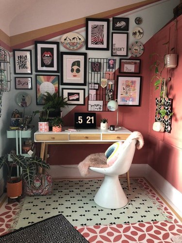 maximalist home office with gallery wall above the desk and coral wall paint