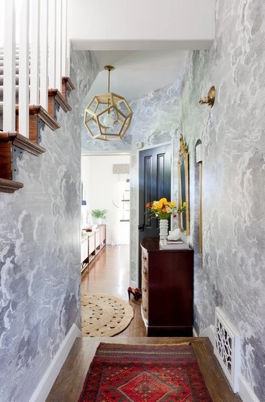 Hallway Pendant Light in Entryway with wallpaper, rug, pendant light, stairs.