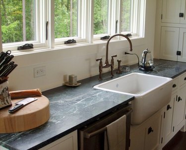 gray soapstone countertops and farmhouse sink with gooseneck bridge faucet