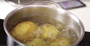 potatoes boiling in a pot of water on the stovetop