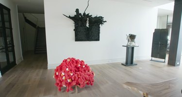 space with artworks including a bright red chair