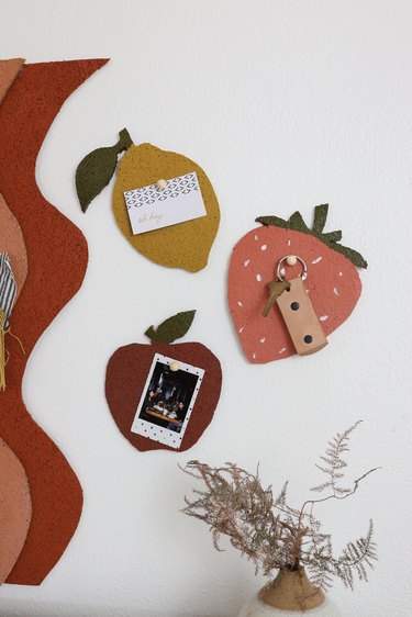 Lemon, strawberry, and apple shape bulletin boards with items pinned to them